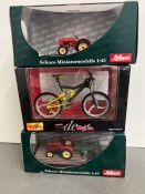 Two Schuco model diecast tractors and one Maisto model of a bike.