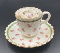 A Mintons tea cup and saucer with pin cushion inset, floral design.