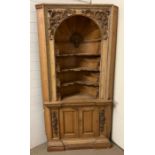 A Victorian carved pine corner cabinet with architectural doomed top and applied carved