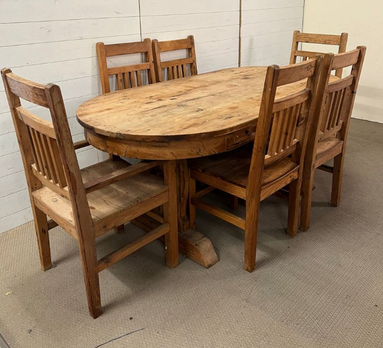 An oval rustic pine table with three drawers, four chairs and two carvers (H75cm W200cm D100cm)