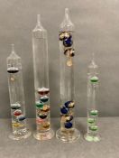 A selection of four glass Galileo thermometer