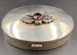 A silver pill box, with floral motif to lid