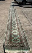 A large runner of green grounds and geometric pattern (2200cm)