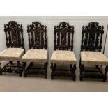 Four dark oak dining chairs with scrolling backs and carved centre flower