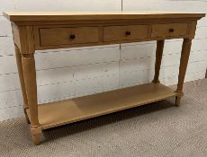 A light oak console table with three drawers on turned legs (H76cm W130cm D38cm)