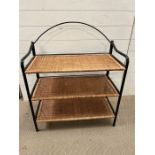 A rattan and metal shelving unit