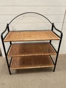 A rattan and metal shelving unit