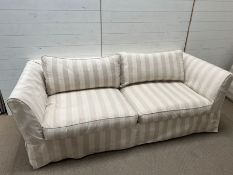 A large two seater sofa with striped loose covers (H72cm W207cm D90cm SH42cm)