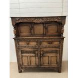 An oak Tudor style court cupboard, carved front opening to storage (H140cm W122cm D49cm)