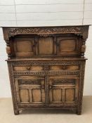 An oak Tudor style court cupboard, carved front opening to storage (H140cm W122cm D49cm)