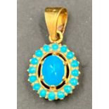 A turquoise stone and gold pendant