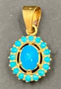 A turquoise stone and gold pendant