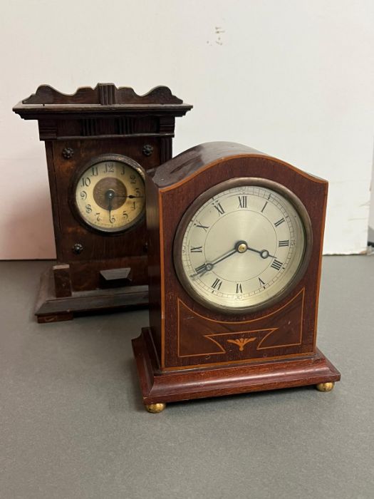 An inlay mantle clock on bun feet and an oak case mantle clock