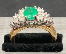 An emerald and diamond set in 18ct gold, central emerald is approx 1 ct. Total diamond weight approx