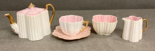 A Wileman and Co pink and white scalloped tea set to include cup and saucer, sugar bowl, tea pot and