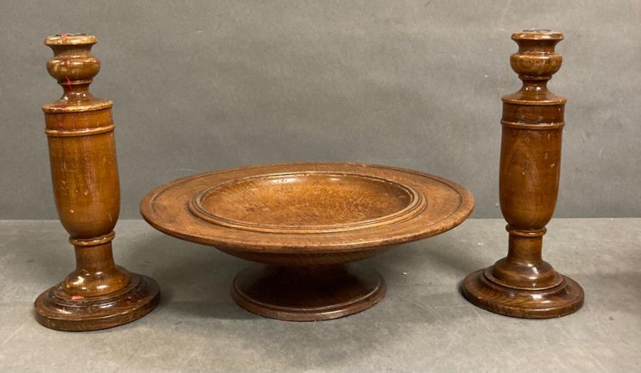 A pair of turned wooden candle sticks and a turned wood raised platter