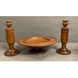 A pair of turned wooden candle sticks and a turned wood raised platter