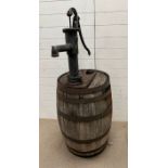 A wooden whisky barrel converted into a garden water pump feature