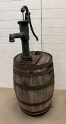 A wooden whisky barrel converted into a garden water pump feature