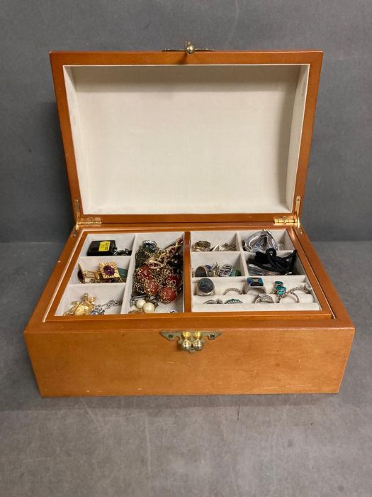 A wooden jewellery box with a selection of costume jewellery