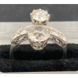 An Art Deco style double diamond ring, set in platinum. The main diamonds weigh approx 1ct and 0.