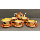 A Clarice Cliff Fantasque pattern tea service to include teapot, four cups, five saucers and a sugar