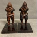 A pair of decorative metal bookends depicting two skiers