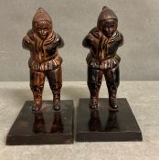 A pair of decorative metal bookends depicting two skiers