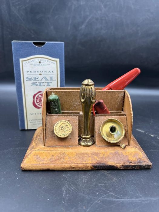 A brass seal set with stamper and wax in a desk top display