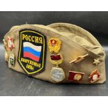 Russian army badges on a Russian military cap with assorted pin badges