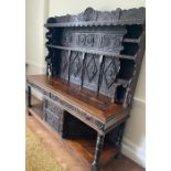 A heavy carved oak dresser with Tudor rose panelling carved figures of Henry VII further carved