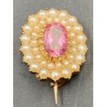 A small 9ct gold brooch with seed pearls and central amethyst style stone.