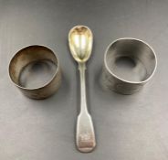 Two hallmarked silver napkin rings and a silver spoon.