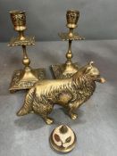 A pair of brass candlesticks along with a dog
