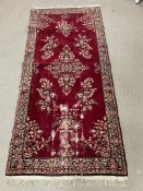 A floral medallion rug with red ground and dark boarder, hand knotted 210cm x 90cm