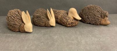 Four decorative wooden animals, two rabbits, a duck and a hedgehog