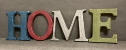 A set of four wooden painted letters spelling "Home"