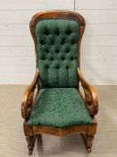 An Edwardian upholstered rocking chair with scrolling arms