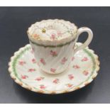 A Minton tea cup and saucer with pin cushion inset, floral design.