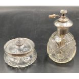 A silver mounted cut glass atomiser and a silver rimmed glass lidded pot.