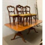 A two leaf extendable dining table with five Victorian style balloon back chairs upholstered in
