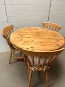 A pine kitchen table with four chairs