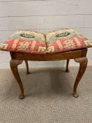 A teak stool with upholstered cushion