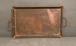 An antique Arts and Crafts hand beaten cooper tray