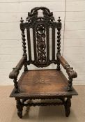 A Charles II style carved oak armchair with a solid seat and spiral turned legs and stretchers