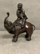 An Oriental bronze of a figure riding an elephant, approx 20cm H.