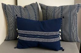 Two decorative cushions and one blue oblong cushion
