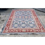 A blue ground rug with a red border depicting birds 370 cm x 240 cm