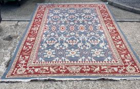 A blue ground rug with a red border depicting birds 370 cm x 240 cm