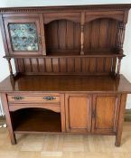 A dresser with stain glass cupboard and open shelves, turned supports on a base with cupboards and